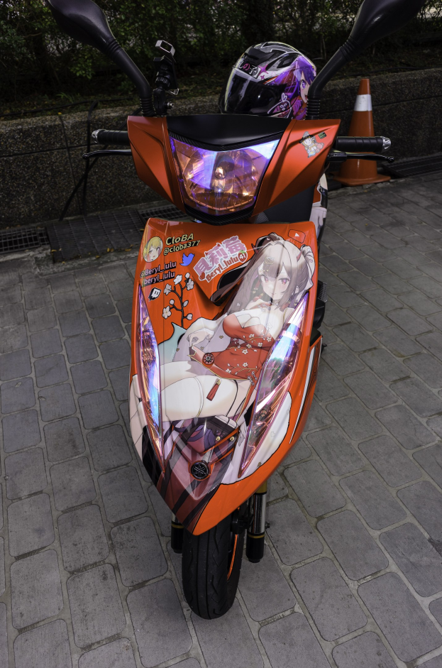 Ein oranges E-Scooter mit einem Helm darauf auf einer Straße geparkt, mit einem Verkehrskegel, einer Wand und Bäumen im Hintergrund.