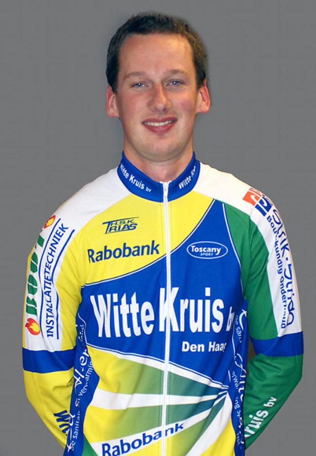 Ein Sportler posiert f√ľr ein Foto, tr√§gt ein Hemd mit verschiedenen Sponsorennamen.