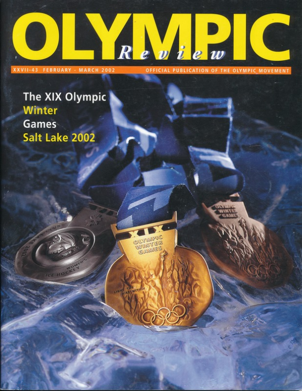 Ein Buch mit dem Titel "Olympic Review Magazine" mit mehreren Medaillen und fetter Schrift auf dem Cover.