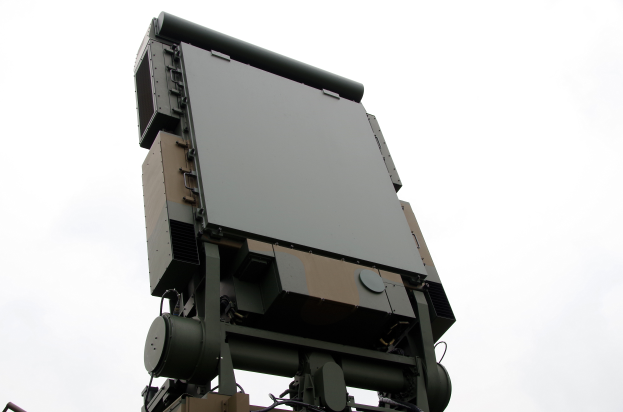 Ein militärisches Fahrzeug mit einem Radar auf dem Dach, vor einem klaren blauen Himmel.