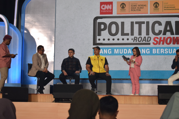 Eine Gruppe von Menschen sitzt auf einer Bühne mit einigen stehenden auf dem Podium davor und ein Schild im Hintergrund mit der Aufschrift "Cnn Political Road Show".