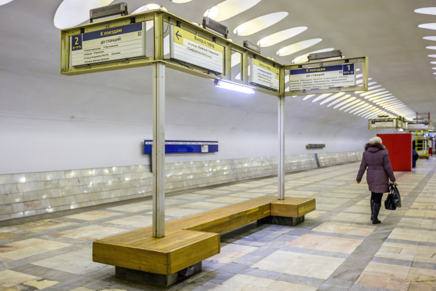 Frau geht durch eine Moskauer U-Bahn-Station und trägt einen Mantel und eine Tasche