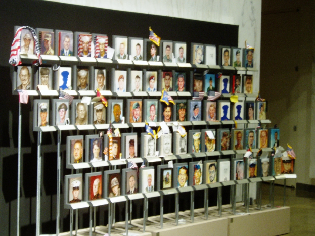 Eine Wand mit mehreren Flaggen und Fotoeinfassungen.