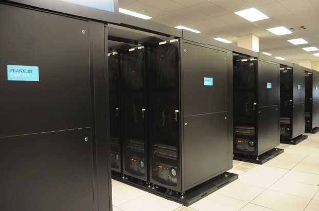 Ein großer Raum voller Numerous Server, mit einem Boden, einer Decke mit Lampen und einer Wand im Hintergrund, was auf ein Rechenzentrum hinweist.