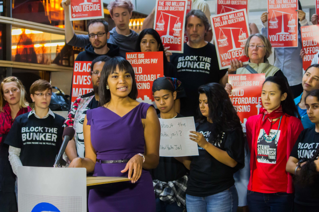 Eine Black-Lives-Matter-Aktivistin spricht vor einer Menge mit Schildern.