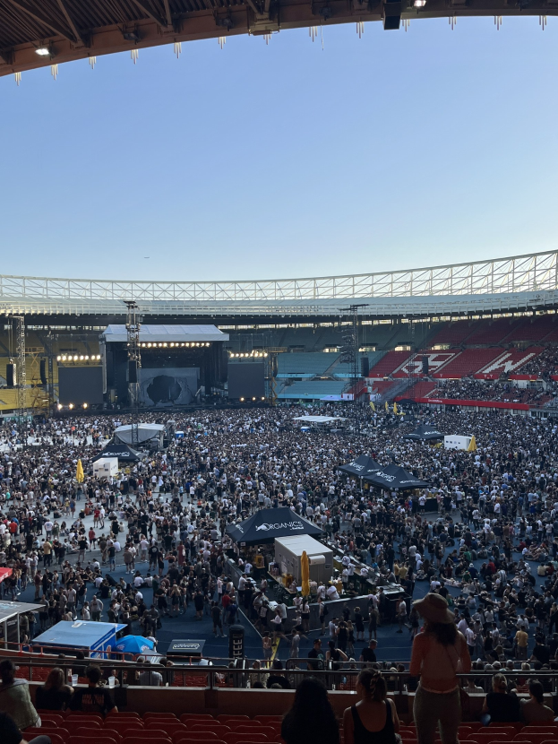 Große Menschenmenge auf Sitzplätzen und Stehplätzen in einem Stadion mit Geländern, Zelten und Überdachung, unter einem Dach in der O2 Arena in London.