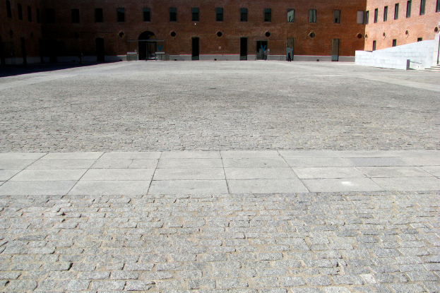 Ein Gebäude mit Glasfenstern oben auf dem Bild, mit Land darunter.