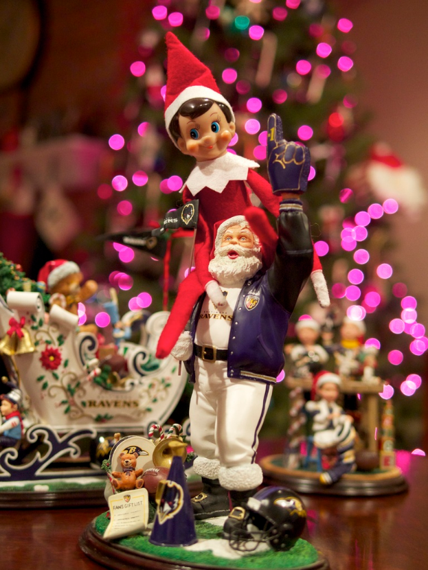 Spielfiguren vorne mit beleuchtetem Weihnachtsbaum im Hintergrund.