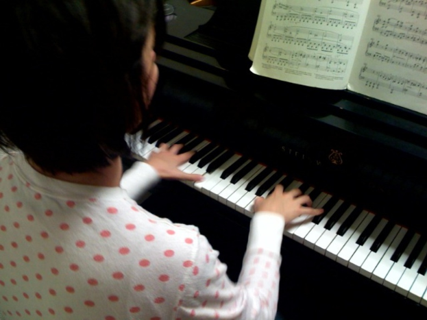 Eine Person, die ein Piano spielt, dargestellt in einer Illustration innerhalb eines Buches.