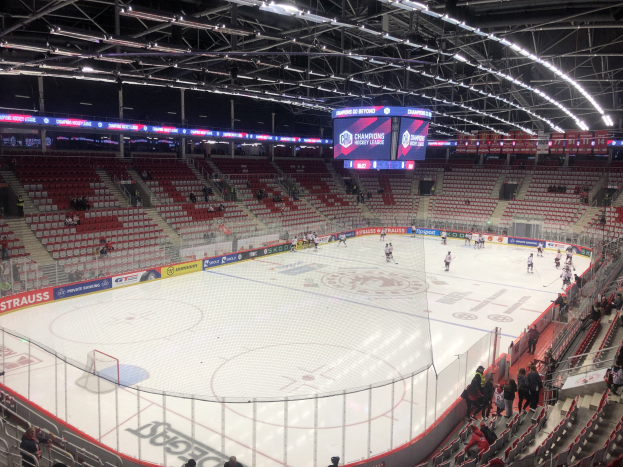 Eishockeyspiel in einer großen Arena zwischen den St. Louis Blues und Detroit Red Wings, mit Zuschauern auf den Sitzen und Stehplätzen in der Nähe der Eisbahn.