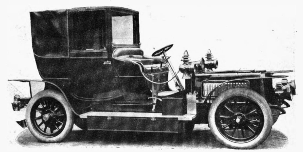 Ein altes Schwarz-Weiß-Foto eines teuren, eleganten Oldtimers mit einer geschwungenen Dachlinie und einem großen, verzierten Motor auf einem weißen Hintergrund.