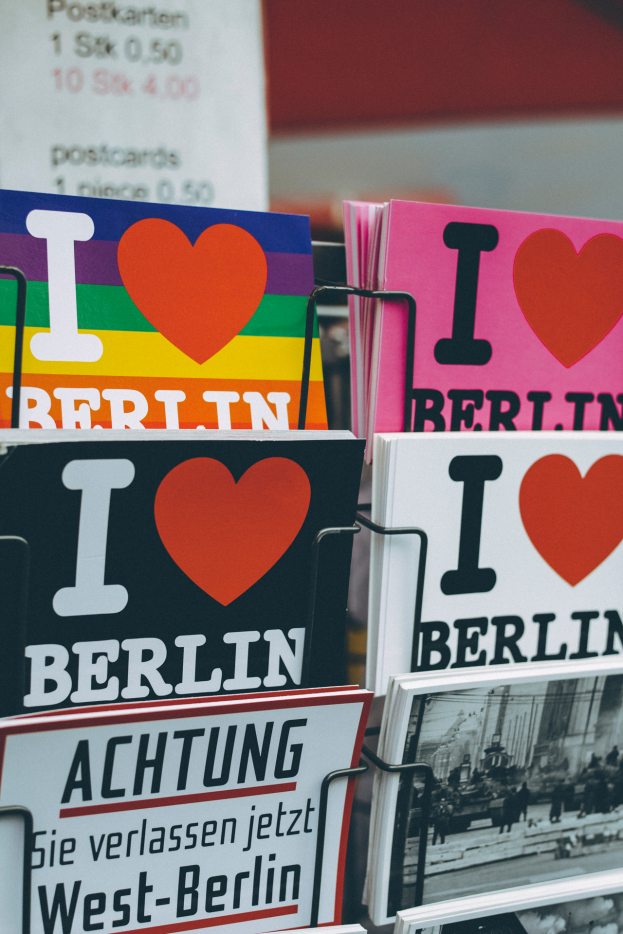 Ein Gestell mit verschiedenen Büchern und Plakaten mit der Aufschrift "Ich liebe Berlin" vor einem unscharfen, träumerischen Hintergrund.