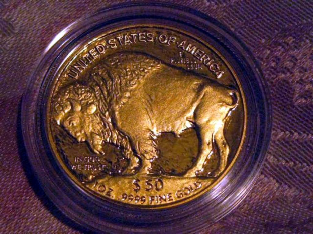 Eine gold- und braune Münze mit der Aufschrift "The United States Of America" darauf, auf einem braunen Teppich.