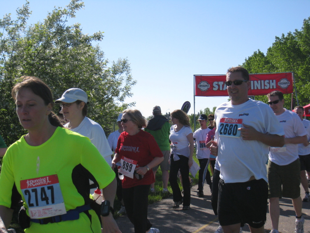 Eine Gruppe von Kindern beim Laufen eines Marathonrennens, mit einem roten Banner und Bäumen im Hintergrund.