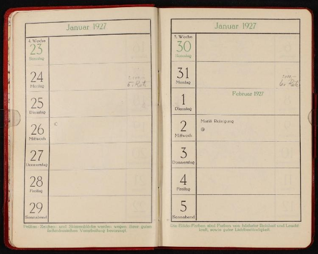 Ein deutsches Tagebuch aus dem Jahr 1927 liegt auf einem dunklen Hintergrund offen, mit einem Kalender darauf.
