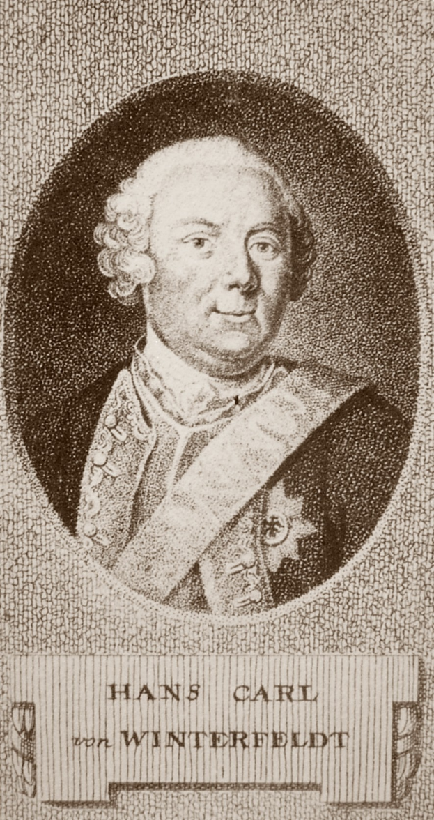 Schwarzes und weißes Foto von Hans Carl von Winterfeldt, ein Mann mit ernster Miene, mit Text unten.