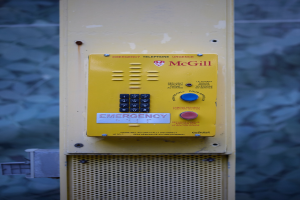 Gelber Notrufknopf an einer Gebäudewand mit Tasten und Text, entworfen für Notrufe.