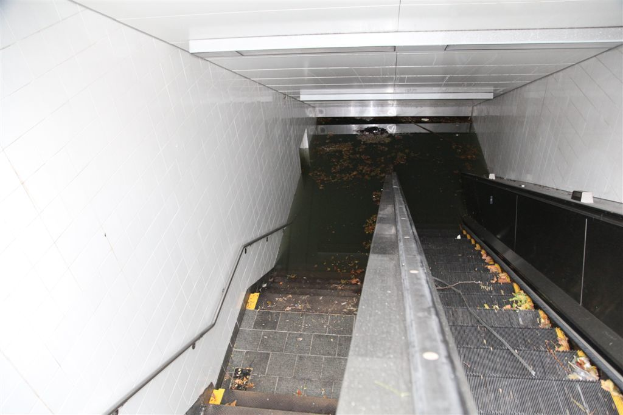 Eine Innenansicht mit einem Dach oben, Wänden auf beiden Seiten, einer Rolltreppe und einer Treppe in der Mitte.