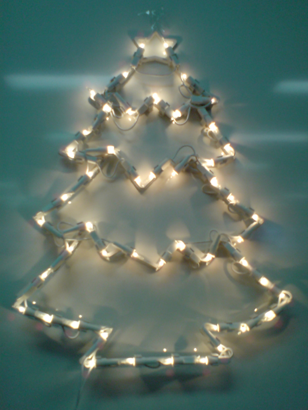 Weihnachtsbaumstruktur mit Lichtern an einer Wand.