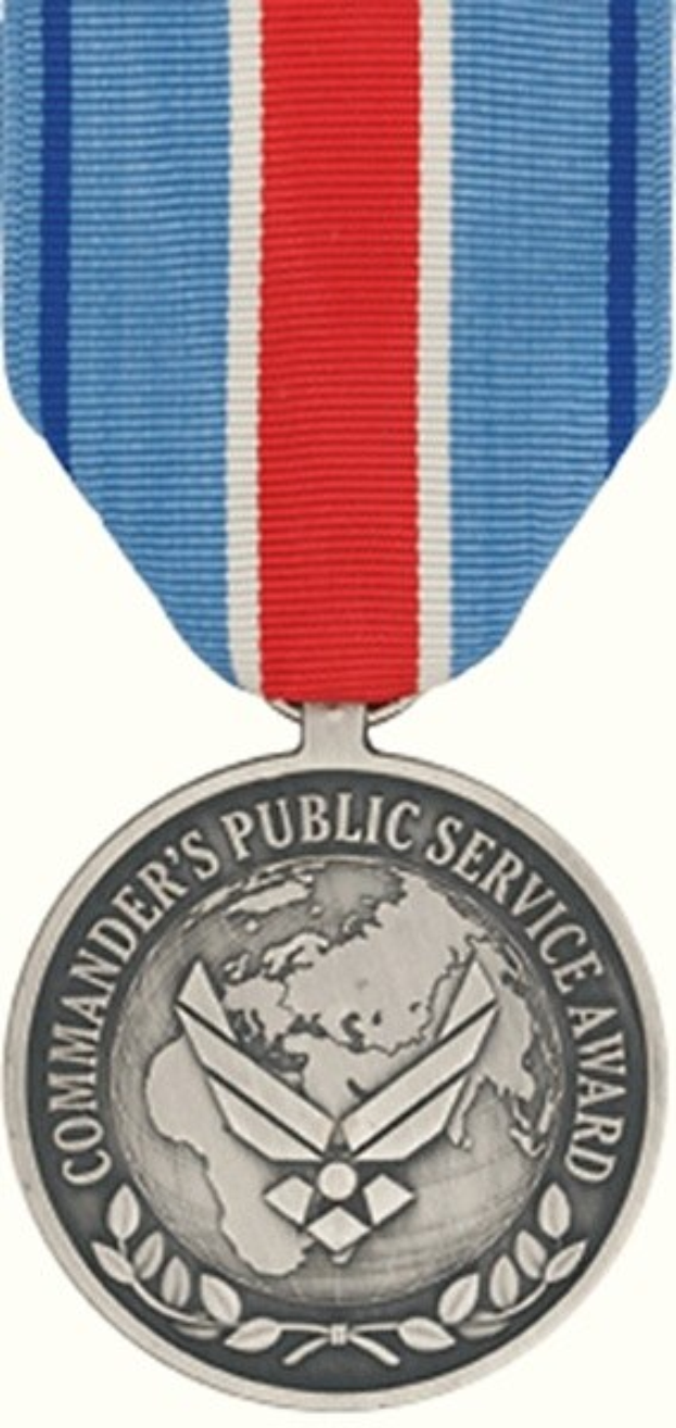 Silberne Medaille mit rot-weiß-blauem Band, beschriftet mit 'Commander's Public Service Award' auf weissem Hintergrund.