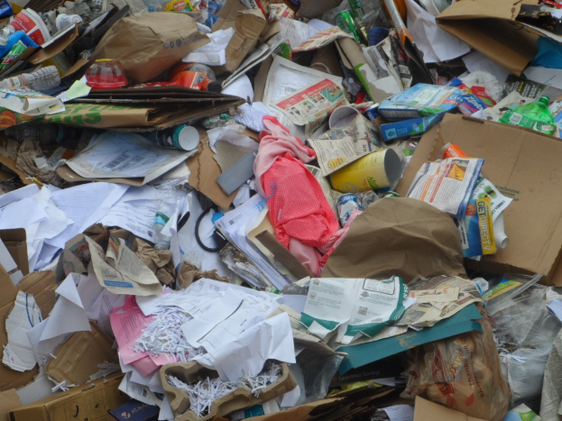 Ein Stapel Kartons mit verschiedenen Gegenständen wie Papieren, Flaschen, Abdeckungen und anderen Gegenständen.